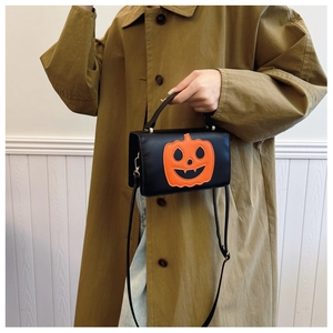 Detail view of Halloween pumpkin crossbody bag in black leather with orange face embroidery