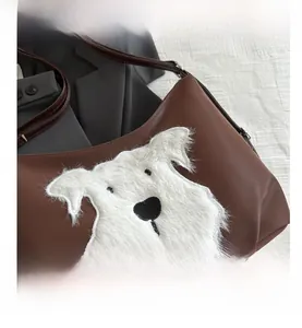 Détail du sac à bandoulière en similicuir marron avec appliqué de chien en peluche