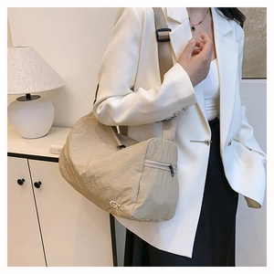 Detail of minimalist nylon shoulder bag with side zipper pocket and wide strap
