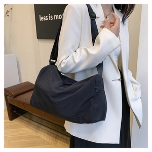 Detail of waterproof nylon shoulder bag featuring side zipper pocket and adjustable strap