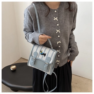 Détail du sac à dos en toile rayée bleu clair avec broderie chiot noir mignon