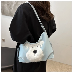 Détail du sac fourre-tout bleu clair avec patch chien 3D en peluche et bandoulière