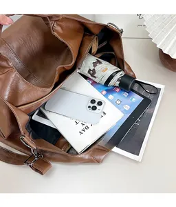 Macro view of large brown PU leather tote bag showing spacious interior with daily items