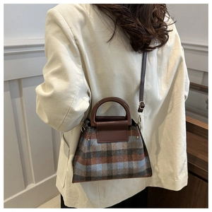 Détail du sac à carreaux vintage porté par un mannequin avec un blazer en velours blanc