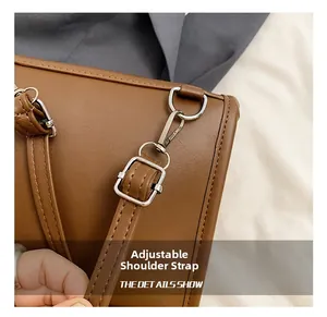 Close-up of adjustable brown leather shoulder strap with silver buckle and hook hardware