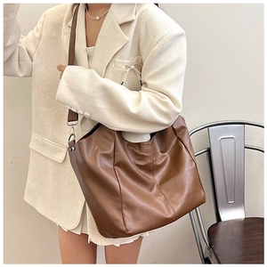 Brown PU leather tote bag styled with a white blazer for a minimalist vintage look