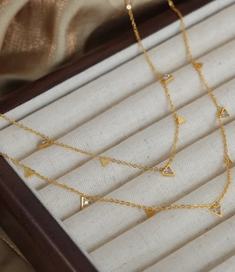 Vue détaillée du collier avec pendentifs triangle en zircon et chaîne dorée