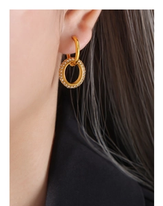 Macro view of double gold hoop earrings with sparkling micro-pave crystals on the ear lobe