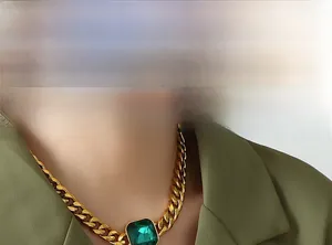Primo piano della catena cubana dorata con ciondolo quadrato in zircone verde smeraldo
