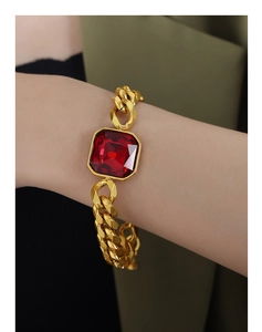Dettaglio del bracciale a catena cubana con grande zircone rosso quadrato dorato