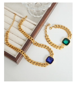 Dettaglio set gioielli catena cubana dorata con pietre di zircone blu e verde smeraldo