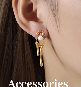 Detalle de los pendientes de oro de 18k con diseño de lava y perlas lucidos por modelo