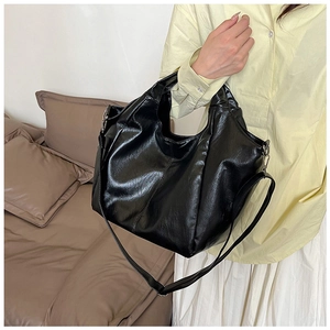 Model showing large black faux leather hobo bag for women with casual commuting style