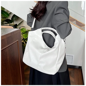 Close-up of minimalist white PU leather tote bag with soft texture and wide shoulder strap