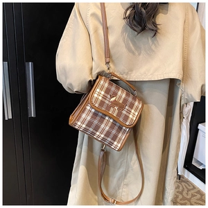 Detailed view of brown plaid crossbody bag with dog patch embroidery and leather trim