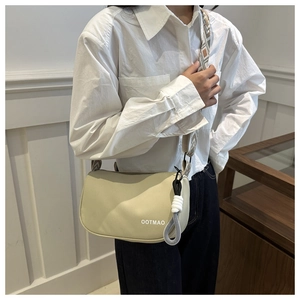 Detail of cream nylon crossbody bag with geometric jacquard strap and knot charm