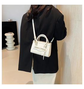 Close-up of white PU leather crossbody bag with decorative zipper and gold hardware details