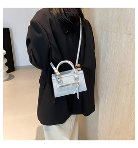 Detail showing light blue mini handbag with zipper tassels and adjustable shoulder strap
