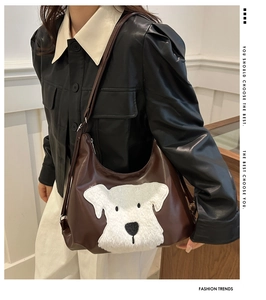 Brown leather tote featuring a plush white dog appliqué on a bright modern background