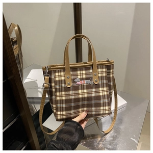 Detailansicht der karierten Beuteltasche mit Dackel-Stickerei und Lederriemen