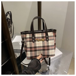 Detail der karierten Beuteltasche mit Dackel-Stickerei und braunen Ledergriffen