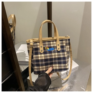 Detail der karierten Beuteltasche mit Dackel-Stickerei und verstellbarem Lederriemen