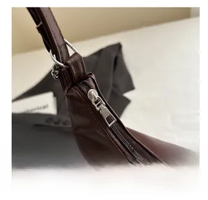 Close-up of smooth silver metal zipper and hardware on vintage brown faux leather tote