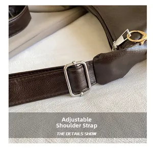 Detail of dark brown lychee grain leather bag with adjustable strap and silver buckle