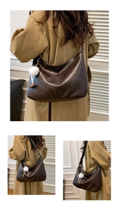 Detail of dark brown hobo bag with vintage texture and white plush charm on a model