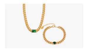 Detailed close-up of emerald-cut green zircon and chunky gold curb chain set