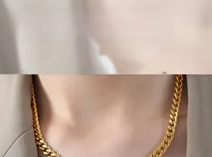 Close-up of gold Cuban link necklace worn with a beige blazer for a retro elegant style