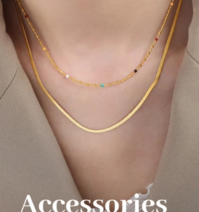 Detalle de collares dorados de dos capas con cadena de serpiente plana y cuentas de colores