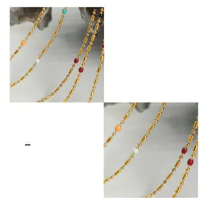 Macro detail of titanium steel chain with 18K gold plating and colorful enamel beads