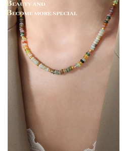 Gros plan de perles en pierres naturelles et espaceurs dorés sur un collier chic