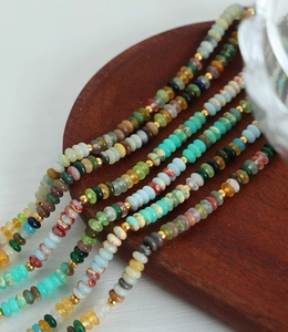 Vue macro de perles en pierre colorées et d'intercalaires en métal doré sur le collier