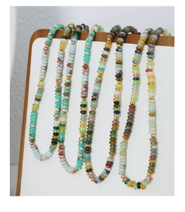 Détail de colliers en perles œil de tigre colorées avec perles de séparation dorées