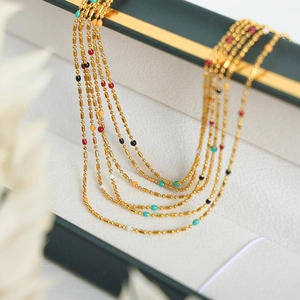 Vintage style multi-layered gold bead necklaces with colorful enamel drips in jewelry box