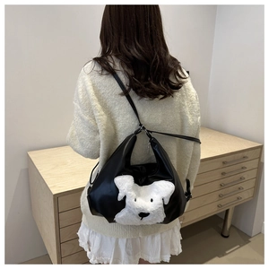Détail du sac cabas en similicuir noir avec un écusson de chiot Schnauzer en peluche blanche