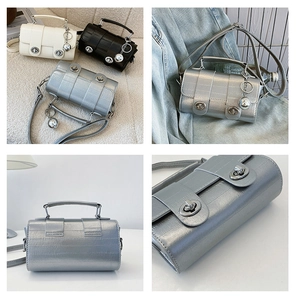 Detail of stylish square mini bags in cream, black, and silver with metal lock and ball charm