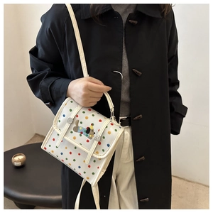 Polka dot crossbody bag with cute dog embroidery shown on model in stylish black coat