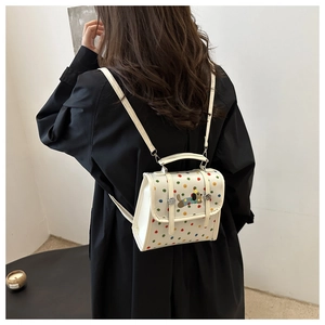 Close-up of cute dog patch embroidery on a white polka dot mini backpack crossbody bag