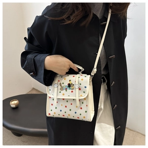 Detail of white crossbody bag with colorful dots and cute cartoon puppy embroidery