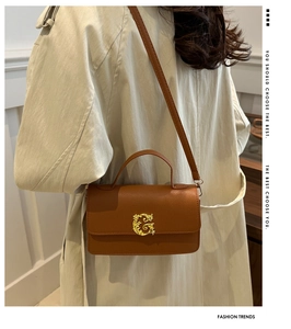 Detail of caramel lychee grain leather crossbody bag with golden G-buckle hardware