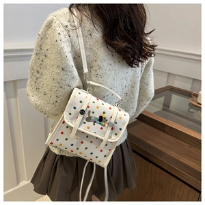 Detail of white multi-functional bag with colorful polka dots and dog embroidery