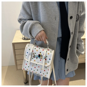 Detail of white crossbody bag with multi-color dots and cute cartoon dog embroidery