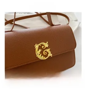 Close-up of caramel brown lychee leather bag with vintage gold Baroque G-logo buckle