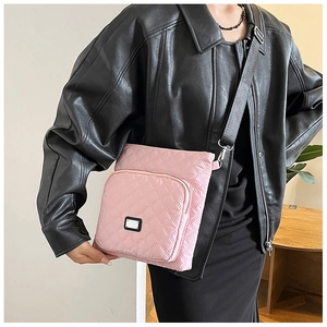 Detailed view of pink quilted nylon crossbody bag with diamond stitching and metal plaque