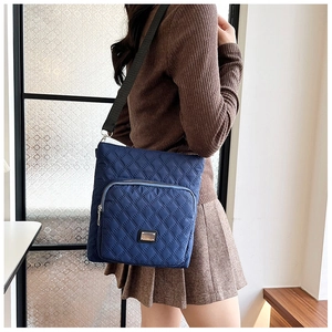 Detail of navy nylon crossbody bag with diamond quilting and adjustable strap for women