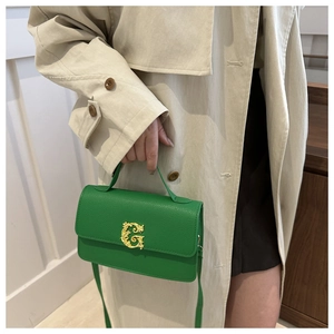 Detail of green pebble leather shoulder bag with vintage gold G metal buckle detail