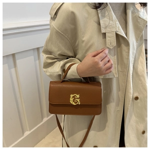 Detail of caramel brown lychee leather bag with a golden Baroque G metal buckle